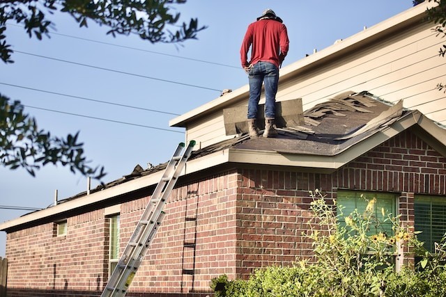 person standing on the roof and repairing it