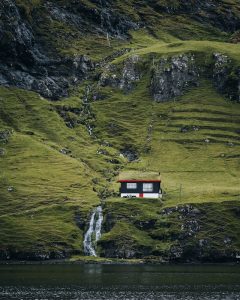 house with fake grass on roof in mountains