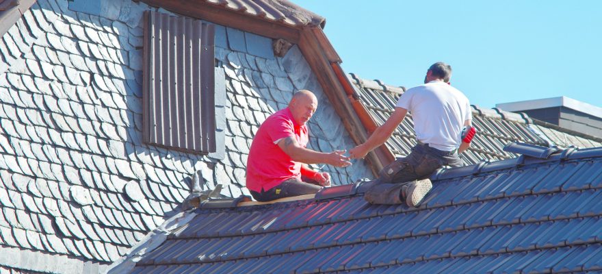 two persons repairing roof