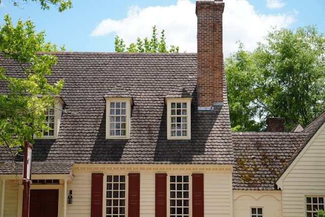 a-white-house-with-red-shutters-and-a-chimney